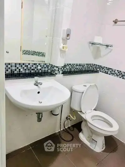 Modern bathroom with sleek white fixtures and stylish tile accents.