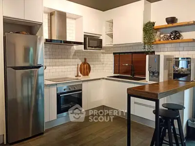 Modern kitchen with sleek appliances and stylish open shelving in a contemporary home.