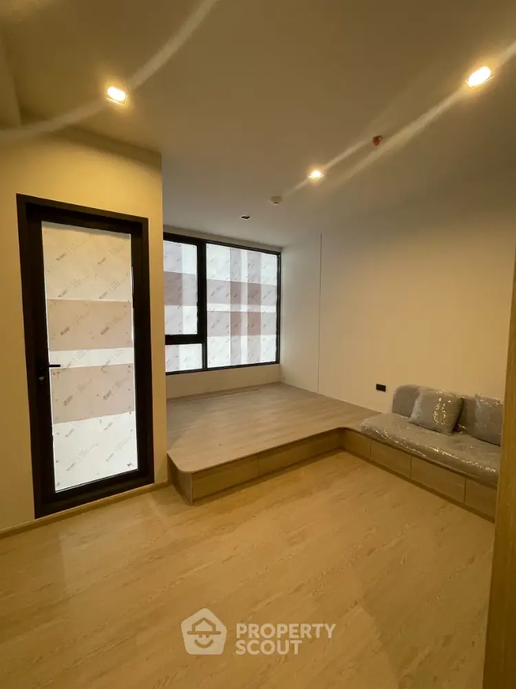 Modern minimalist room with wooden flooring and built-in seating area