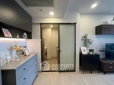 Modern living room with sleek decor and sliding door to storage area.