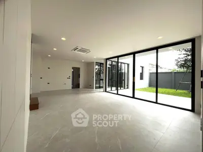 Spacious modern living room with large windows and garden view