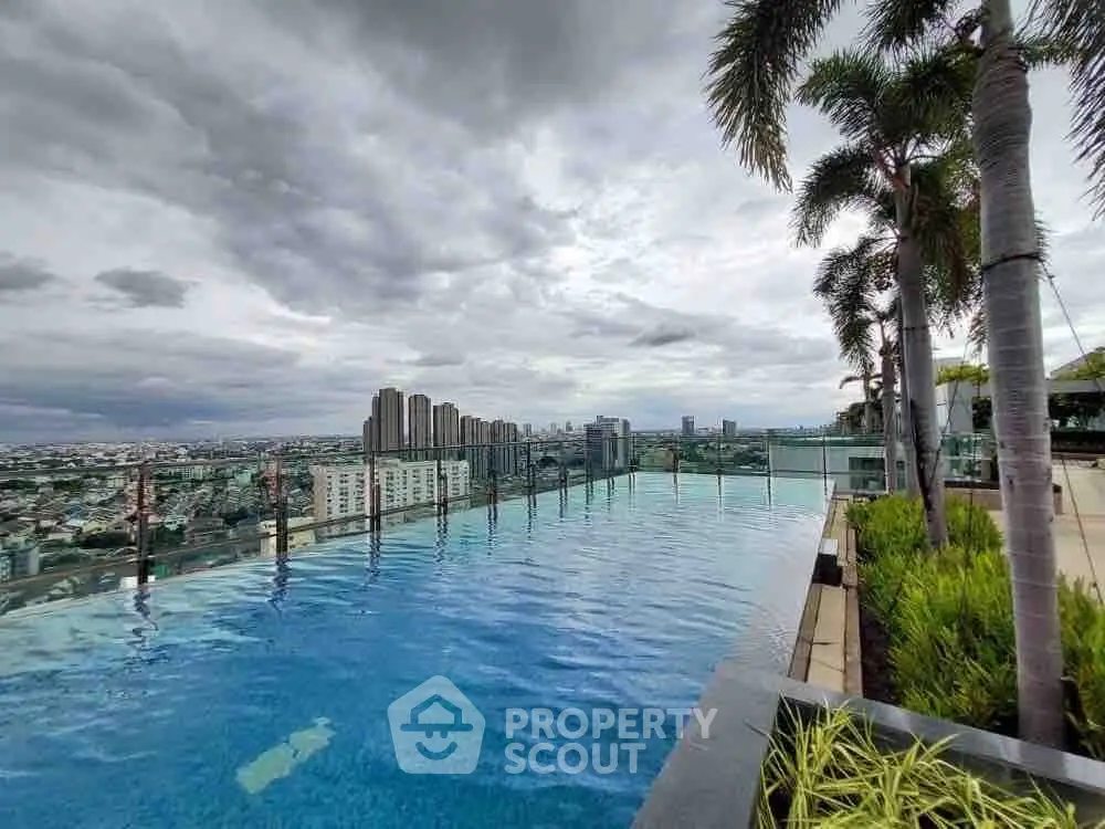 Stunning rooftop infinity pool with panoramic city views and lush palm trees.