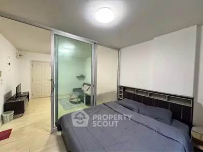 Modern bedroom with sliding glass doors and cozy living area