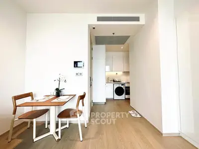 Modern open-plan kitchen and dining area with wooden flooring and sleek appliances.
