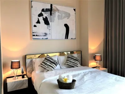 Elegant bedroom with modern decor and stylish lighting, featuring a cozy bed and abstract artwork.