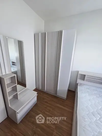 Modern bedroom with sleek furniture and wooden flooring, perfect for a cozy living space.