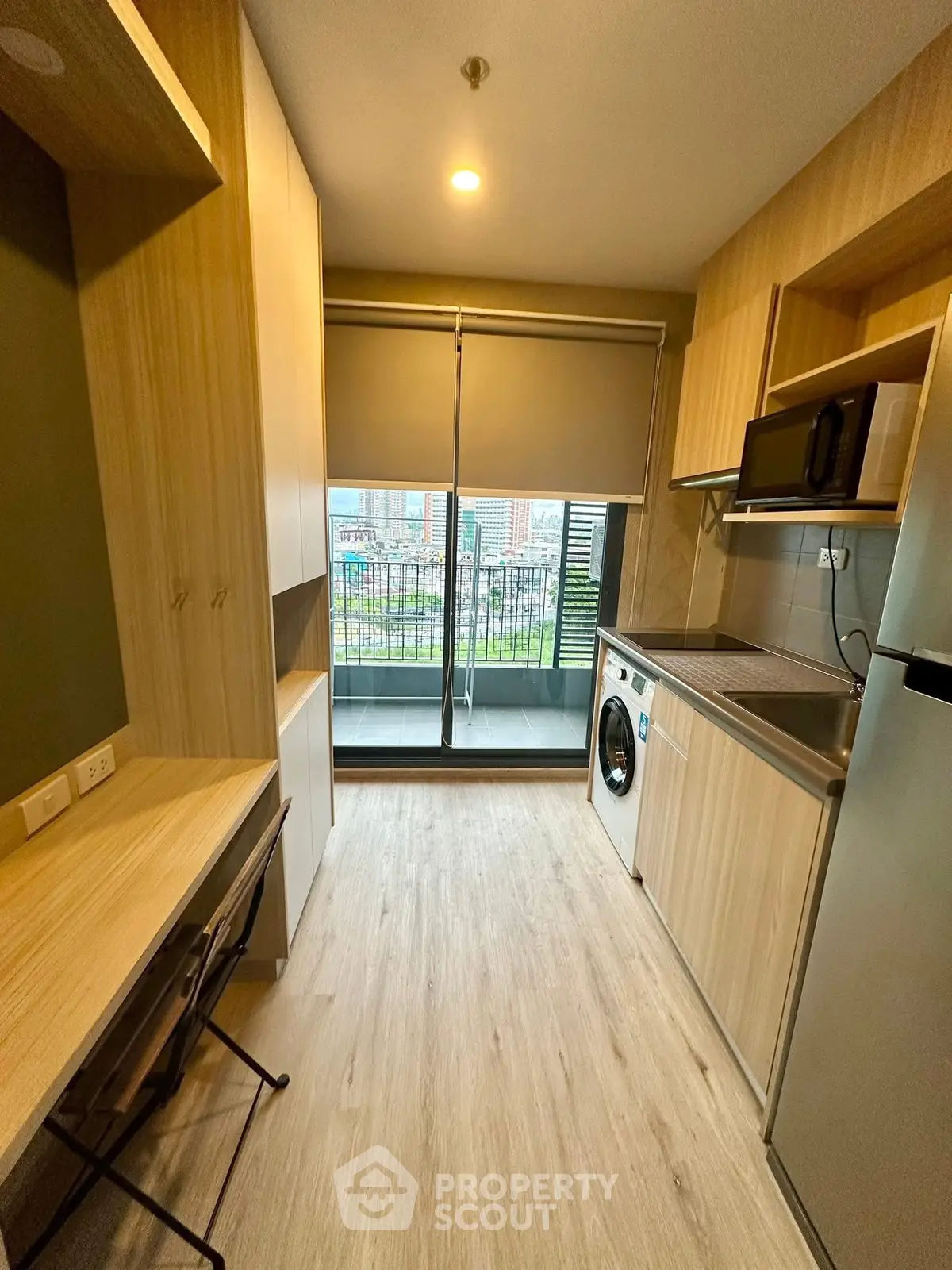 Modern compact kitchen with balcony view and built-in appliances