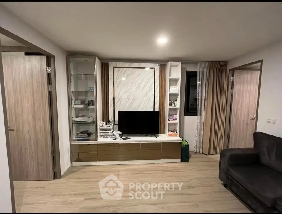 Modern living room with sleek TV unit and cozy sofa in stylish apartment.