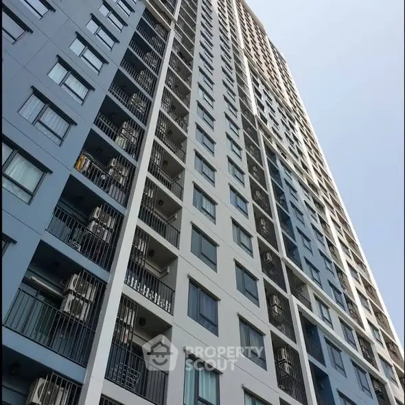 Modern high-rise residential building with sleek design and multiple balconies.