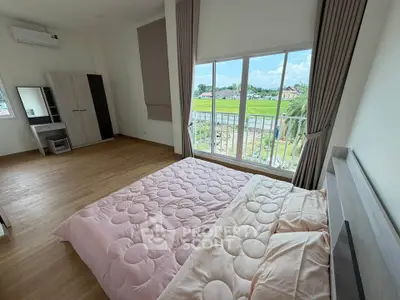 Spacious bedroom with large window offering scenic views, featuring modern furniture and elegant decor.