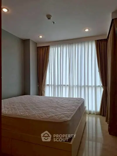 Spacious bedroom with large window and elegant curtains in modern apartment