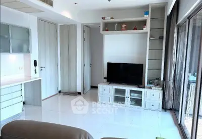 Modern living room with sleek TV unit and large windows for natural light.