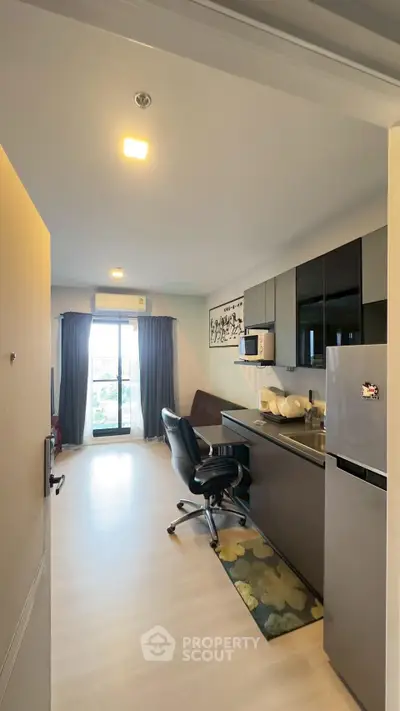 Modern apartment with sleek kitchen and cozy living area, featuring large windows and stylish decor.