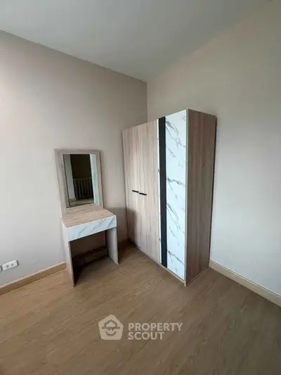 Modern bedroom with stylish wardrobe and matching vanity set on wooden flooring.