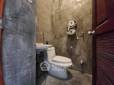 Industrial-style bathroom with concrete walls and modern fixtures.