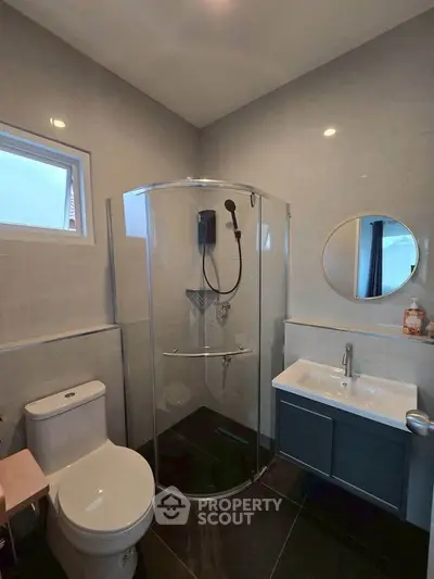 Modern bathroom with sleek shower and stylish vanity in contemporary home.