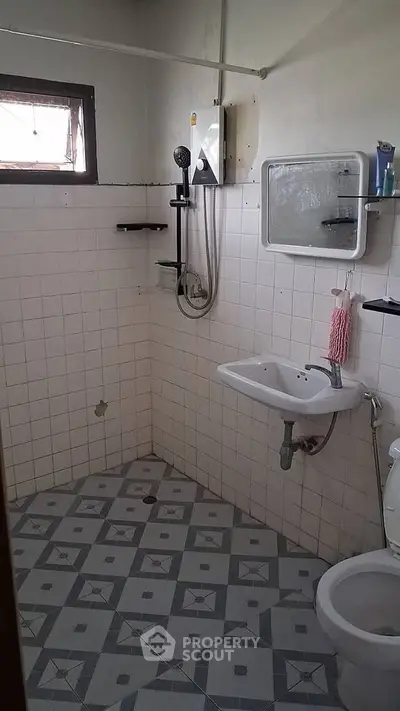 Compact bathroom with white tiles and basic fixtures, ideal for small spaces.