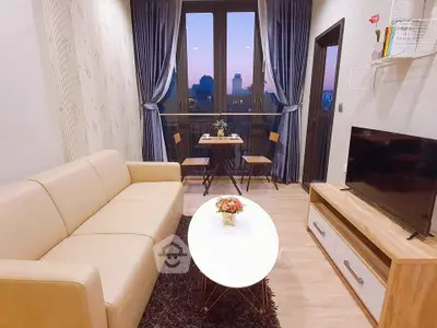 Charming living room with cozy sofa and balcony view at sunset.