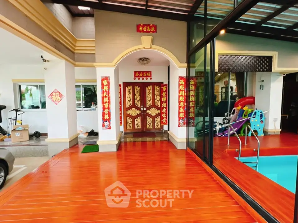 Luxurious home entrance with vibrant red decor and indoor pool, perfect for elegant living.