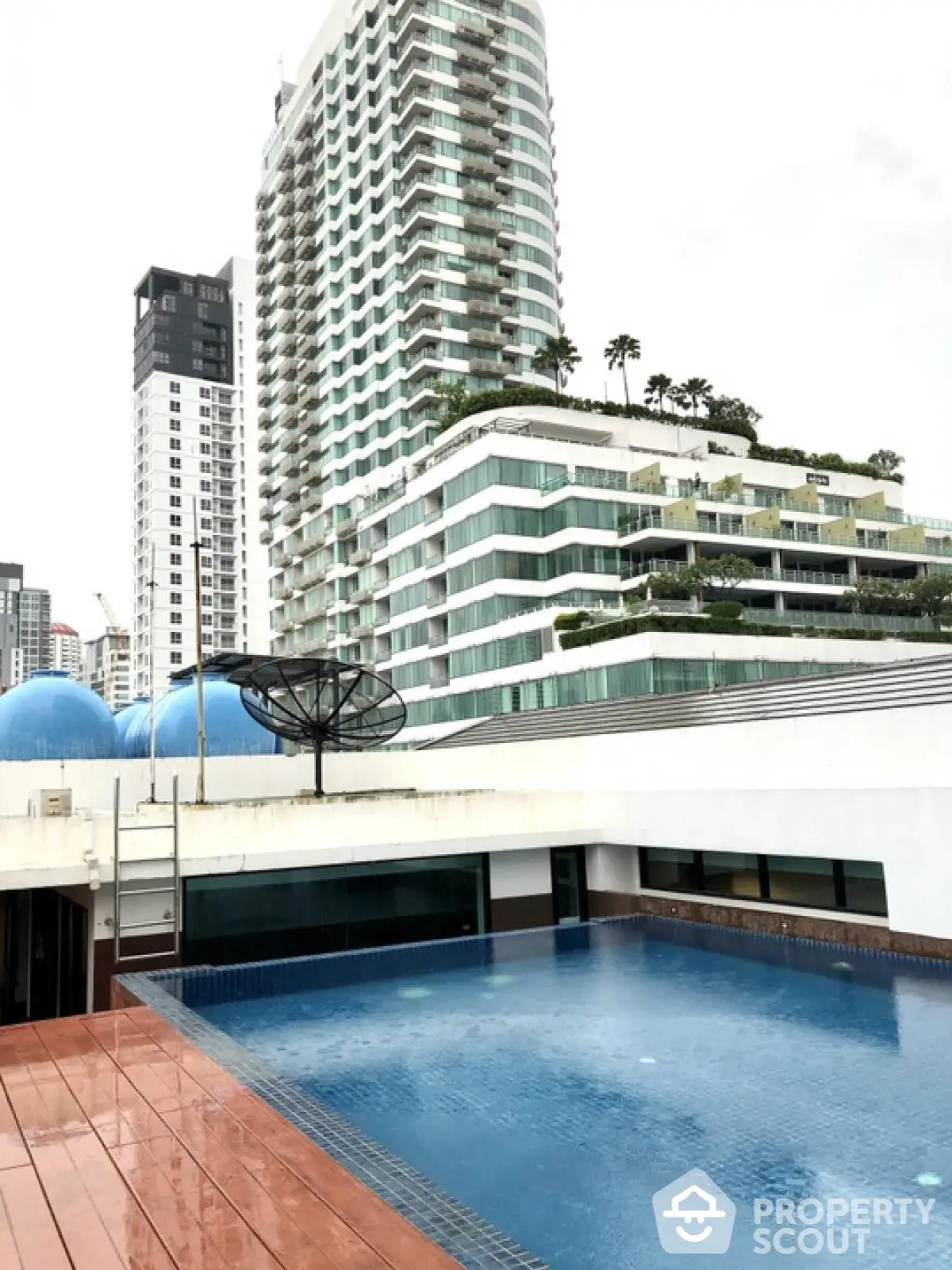 Luxurious rooftop pool with stunning cityscape views in modern high-rise building.