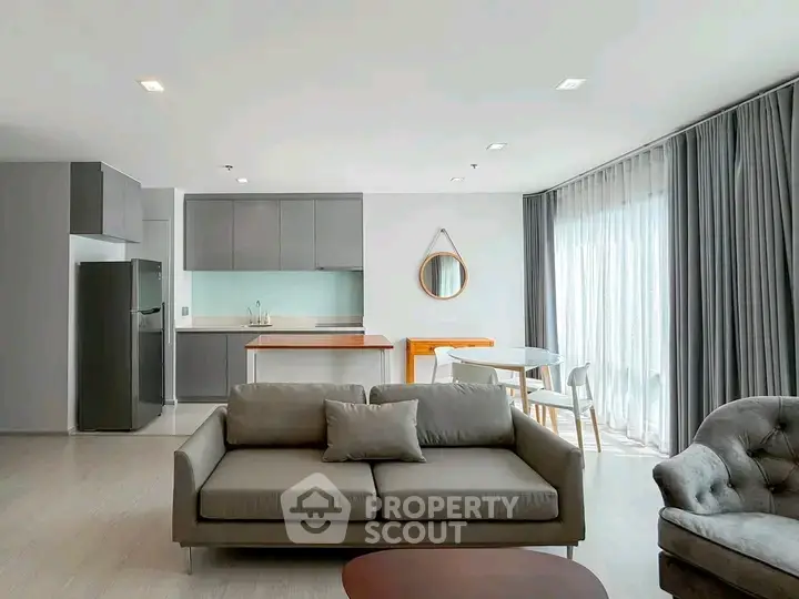 Modern open-plan living room with sleek kitchen and stylish furniture