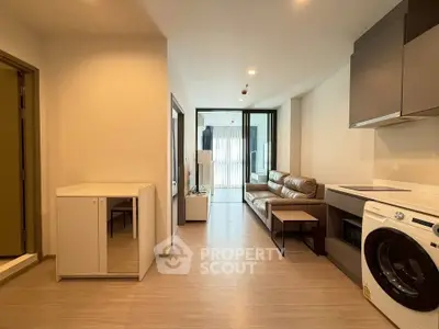 Modern apartment interior with open layout, featuring a cozy living area and a convenient in-unit washing machine.