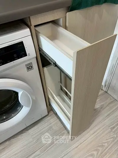 Modern kitchen with washing machine and sleek pull-out storage drawer