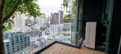 Stunning cityscape view from a modern balcony with lush greenery and sleek design.