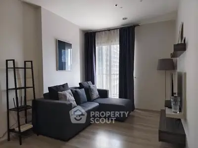 Modern living room with stylish gray sofa and floor-to-ceiling window curtains.