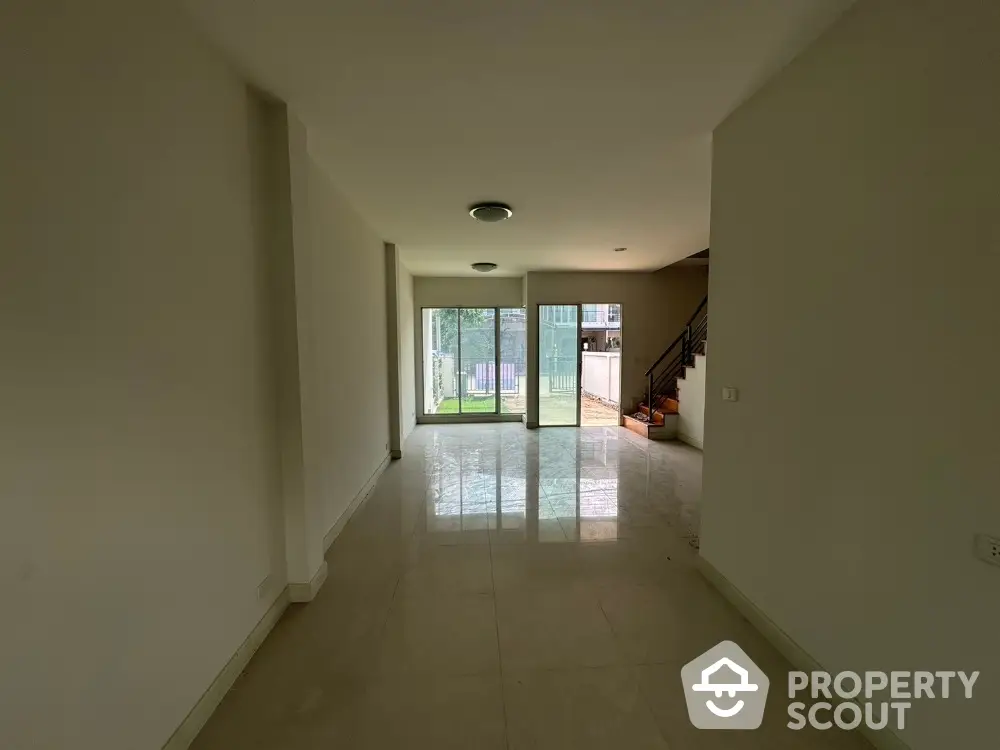 Spacious empty living room with large windows and garden view