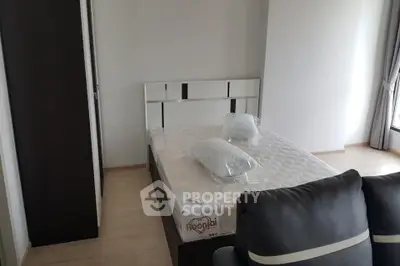 Modern bedroom with sleek furniture and natural light, perfect for a cozy living space.