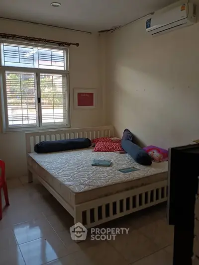 Cozy bedroom with large window and air conditioning, perfect for relaxation.