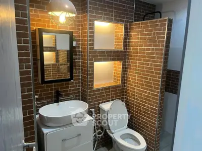 Modern bathroom with brick accent wall and stylish lighting