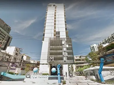 Modern high-rise building with grand opening sign and contemporary architecture.