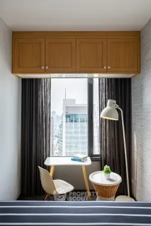 Modern study nook with city view, featuring sleek desk, chair, and floor lamp in a stylish apartment.