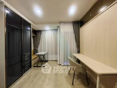 Modern study room with sleek design and ample natural light, featuring a large desk and comfortable chair.