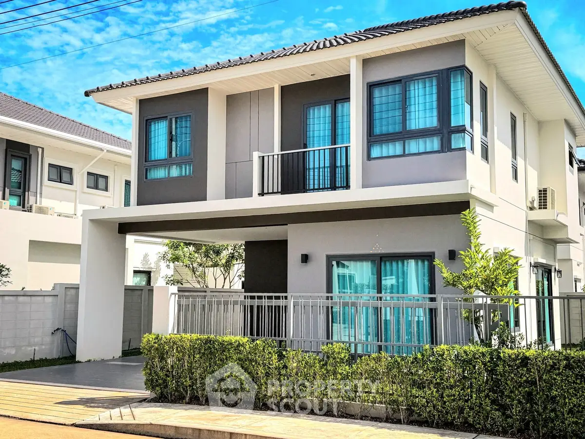 Modern two-story house with large windows and a sleek exterior design.