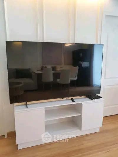 Modern living room with sleek TV setup and elegant dining area