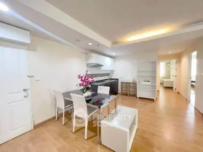 Spacious open-plan living and dining area with modern furnishings and bright lighting.