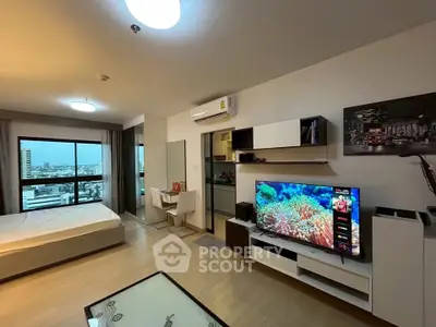 Modern studio apartment with open layout and city view, featuring stylish furniture and entertainment setup.