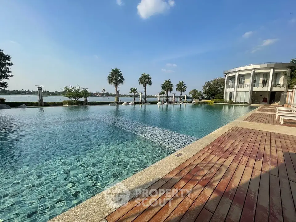 Luxurious poolside view with palm trees and modern architecture, perfect for relaxation and leisure.