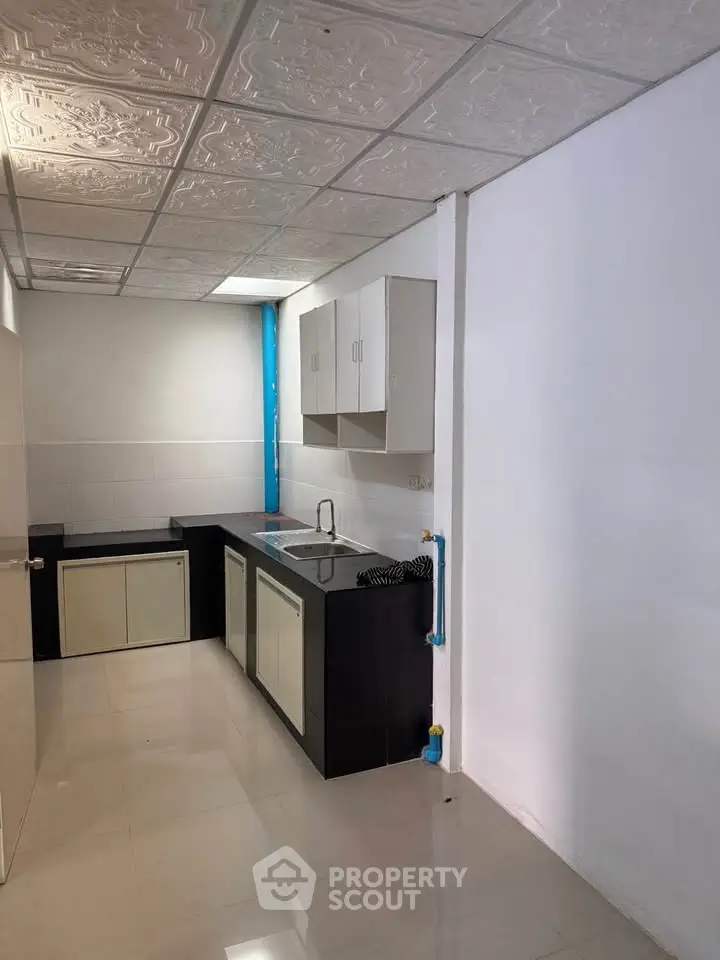 Modern kitchen with sleek cabinetry and tiled flooring in a compact layout.