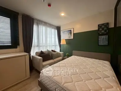 Cozy bedroom with modern decor, featuring a comfortable bed, stylish sofa, and large window for natural light.