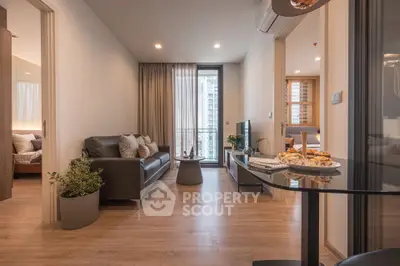 Modern living room with cozy seating and natural light, adjacent to a stylish bedroom.