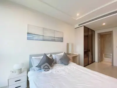 Modern bedroom with elegant decor and ensuite bathroom in a stylish apartment.