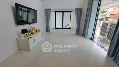 Spacious living room with modern decor and large windows for natural light.