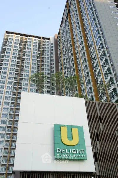 Modern high-rise condominium building with stylish facade and prominent signage