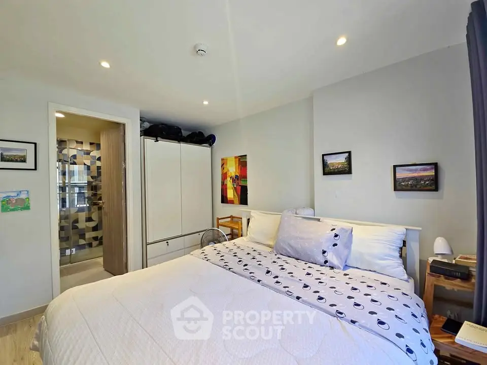Cozy bedroom with modern decor and ensuite bathroom in a stylish apartment.
