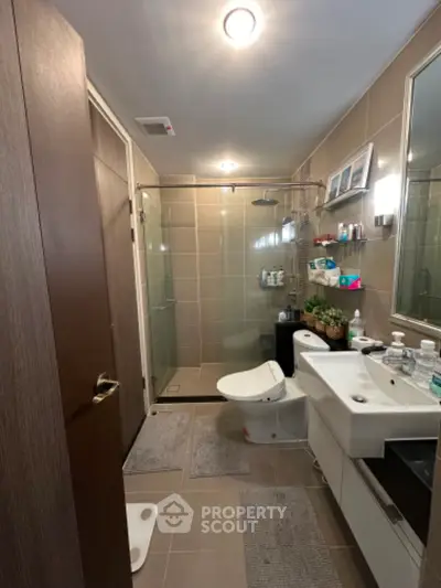 Spacious modern bathroom with glass shower enclosure, well-lit vanity area, and ample storage, perfect for a refreshing start to the day.