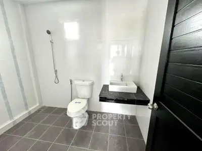 Modern minimalist bathroom with sleek fixtures and tiled flooring